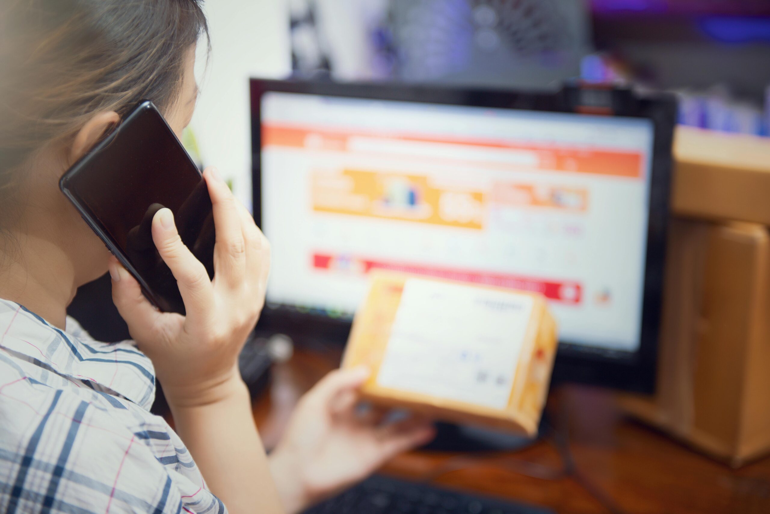 Woman multitasking with phone and online shopping